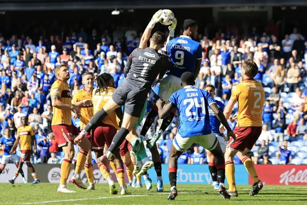 Calum Ward of Motherwell catches a corner under pressure from Jack Butland of Rangers (left) and Youssef Chermiti of Rangers during the William Hill Premiership match at Ibrox Stadium, Glasgow 26/04/2026