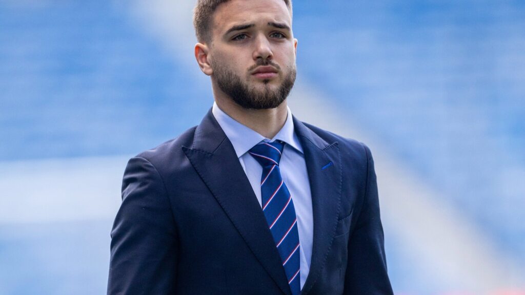 Raskin and Neil: Nicolas Raskin in a suit, posed in a pre-match or formal club context