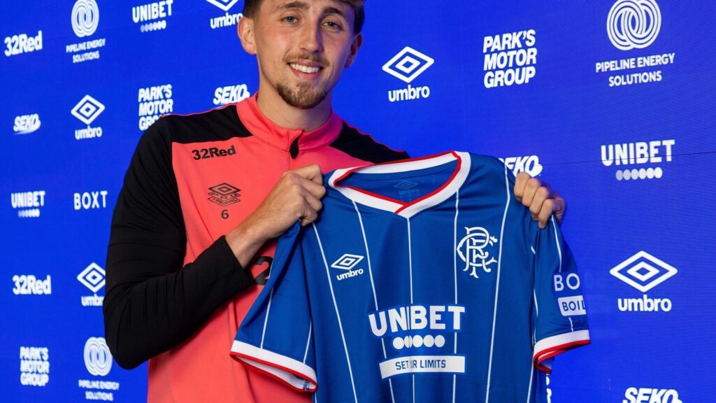 Kris Boyd Dan Neil Rangers: Dan Neil posing with a Rangers FC home kit during a unveiling media session.